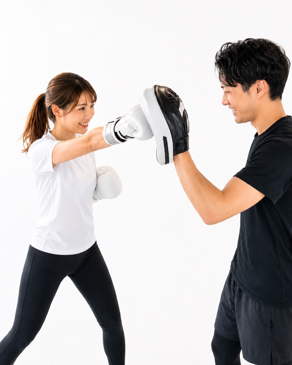 ミット打ちを楽しむ女性と、ミットを構える男性コーチ